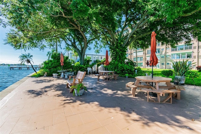 view of property's community with a water view and a patio area