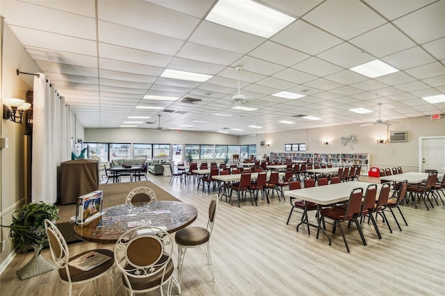 1847 Shore Dr S Unit 614, South Pasadena, FL 33707 - dining area with a wall mounted AC, wood finished floors, ceiling fan, and a paneled ceiling