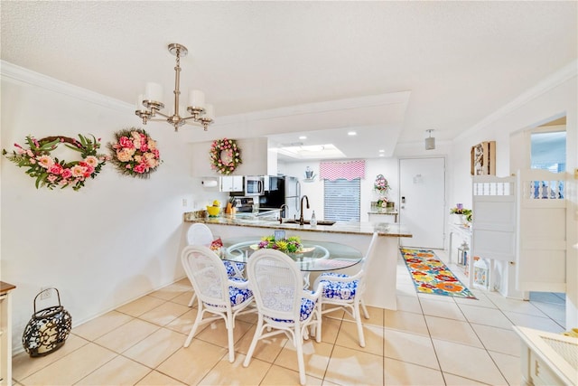 tiled dining space with ornamental molding, sink, and an inviting chandelier