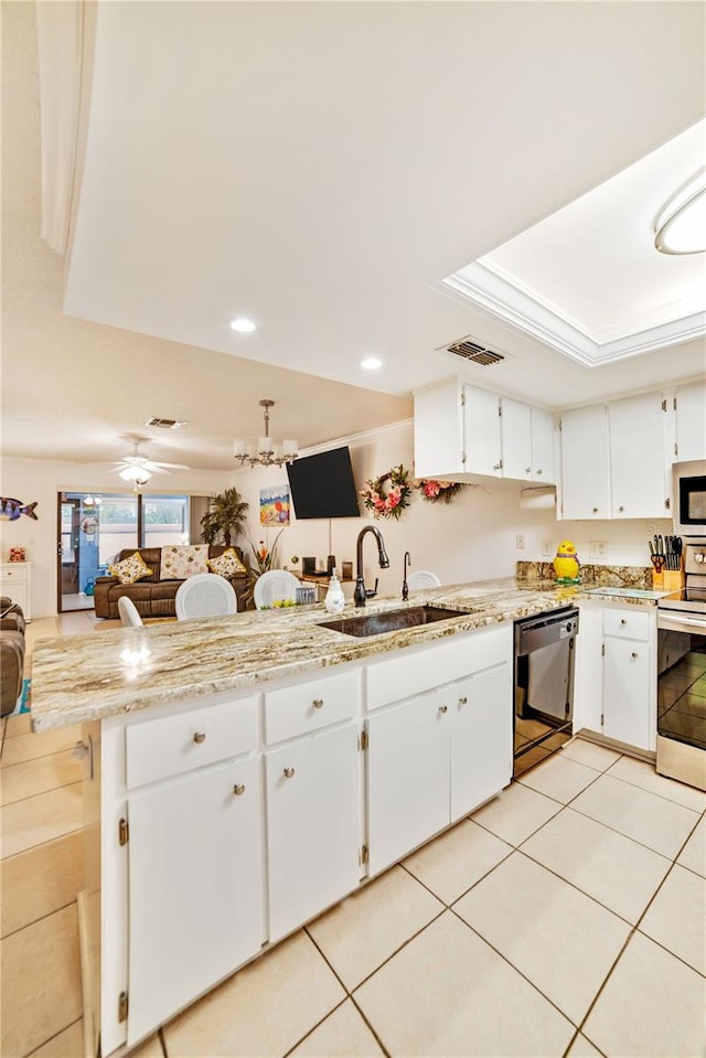 kitchen with sink, kitchen peninsula, light stone countertops, white cabinetry, and stainless steel appliances