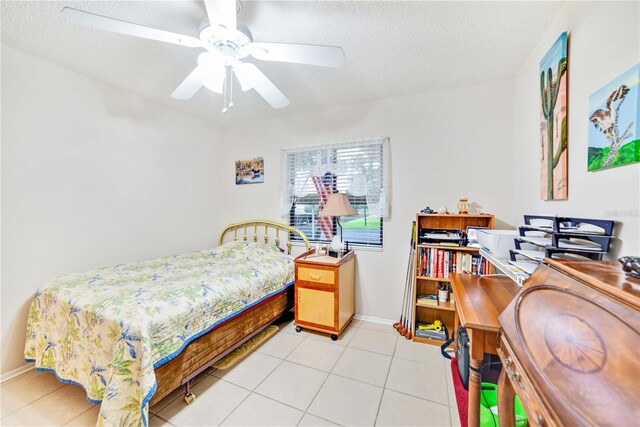 bedroom with ceiling fan, light tile patterned flooring, and a textured ceiling