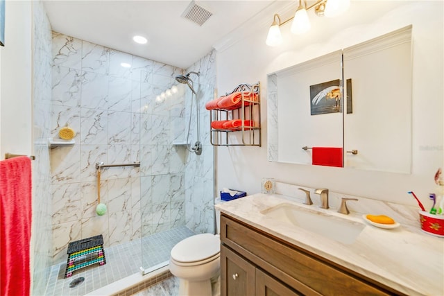 bathroom with tiled shower, vanity, and toilet