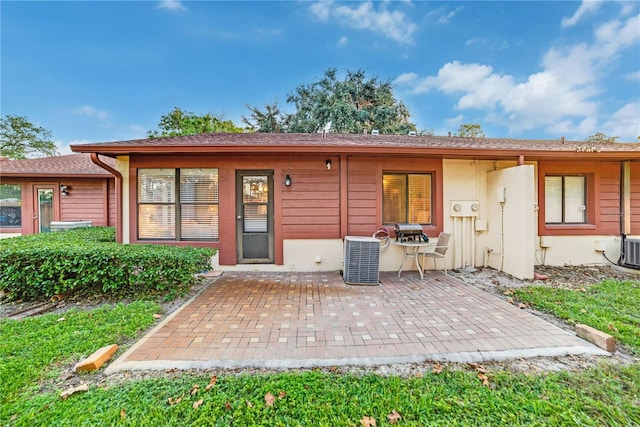 rear view of property featuring central air condition unit and a patio area