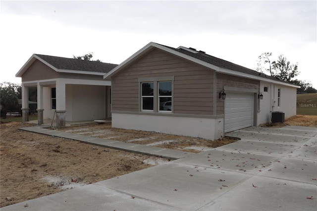 view of front facade with central AC unit and a garage