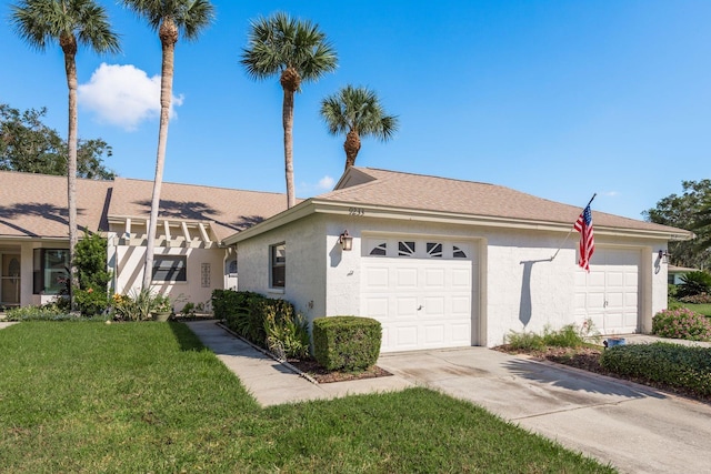 ranch-style home with a garage and a front lawn