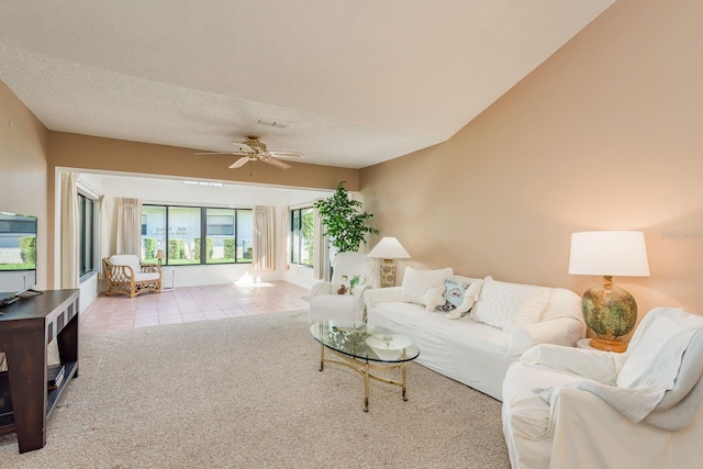 living room featuring ceiling fan, a textured ceiling, and light carpet