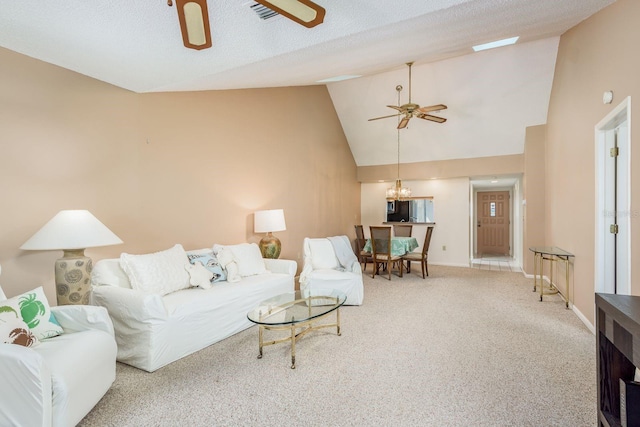 carpeted living room featuring ceiling fan with notable chandelier, a textured ceiling, and high vaulted ceiling