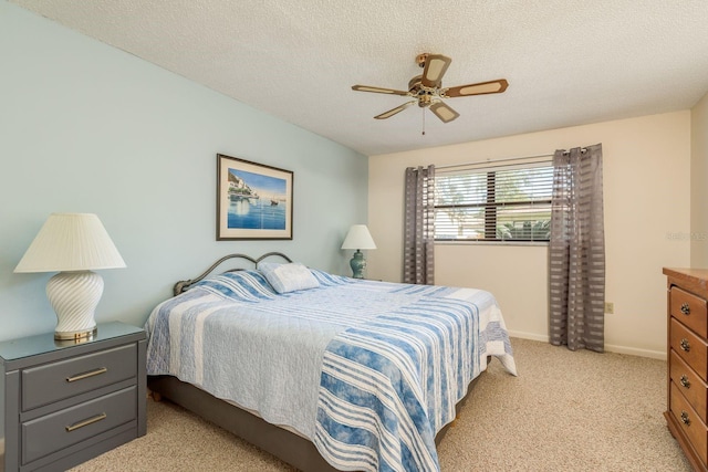 bedroom with ceiling fan, a textured ceiling, and light carpet