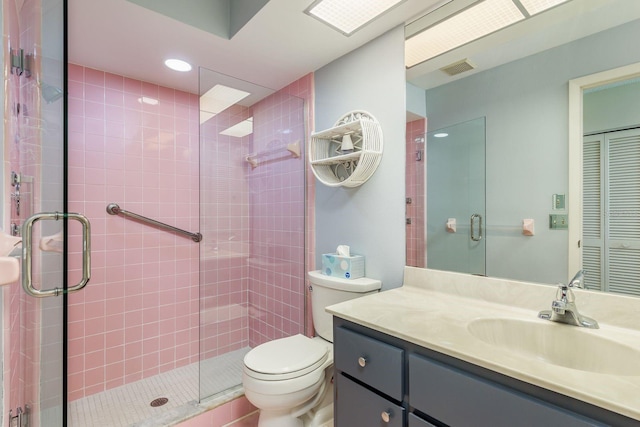 bathroom featuring vanity, toilet, and a shower with door