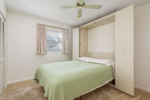 carpeted bedroom featuring ceiling fan, a textured ceiling, and a closet