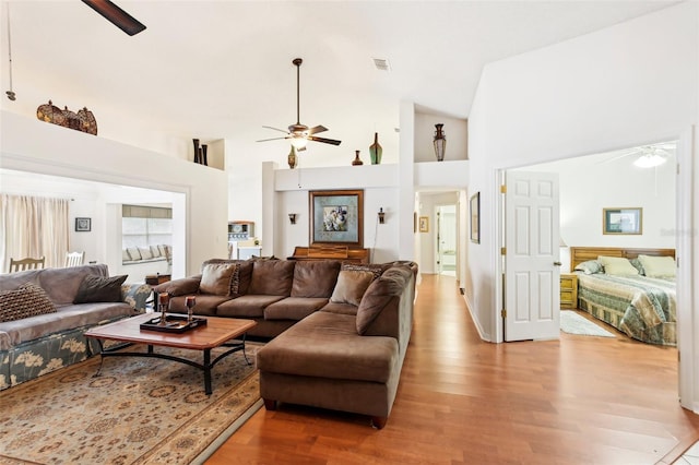 living room featuring high vaulted ceiling, light hardwood / wood-style floors, and ceiling fan