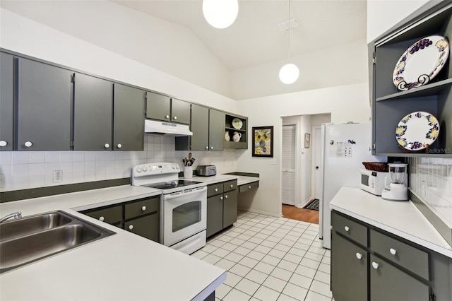 kitchen featuring tasteful backsplash, sink, lofted ceiling, white appliances, and light tile patterned floors