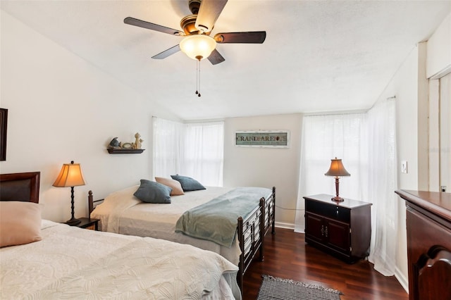 bedroom with vaulted ceiling, ceiling fan, and dark wood-type flooring