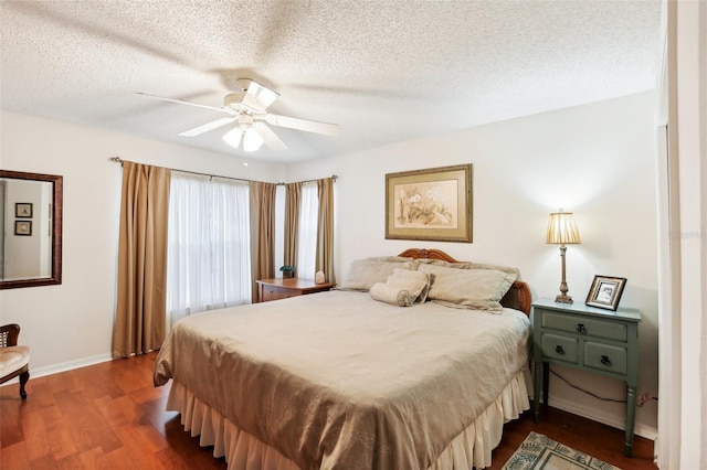 bedroom with ceiling fan, a textured ceiling, and dark hardwood / wood-style flooring