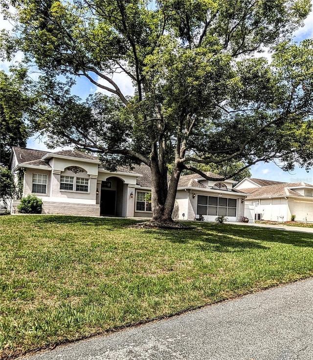 8088 Spanish Oak Dr, Spring Hill, FL 34606 - ranch-style house with a front lawn and stucco siding