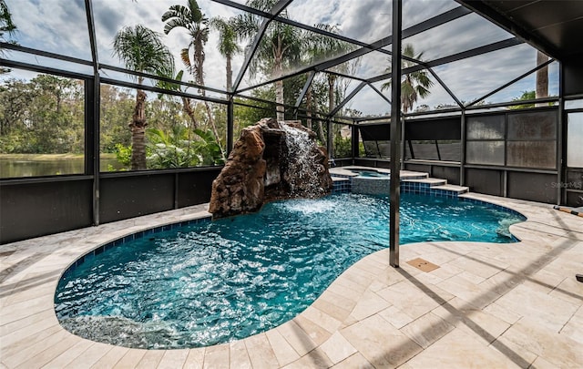 view of pool with an in ground hot tub, a patio area, and glass enclosure