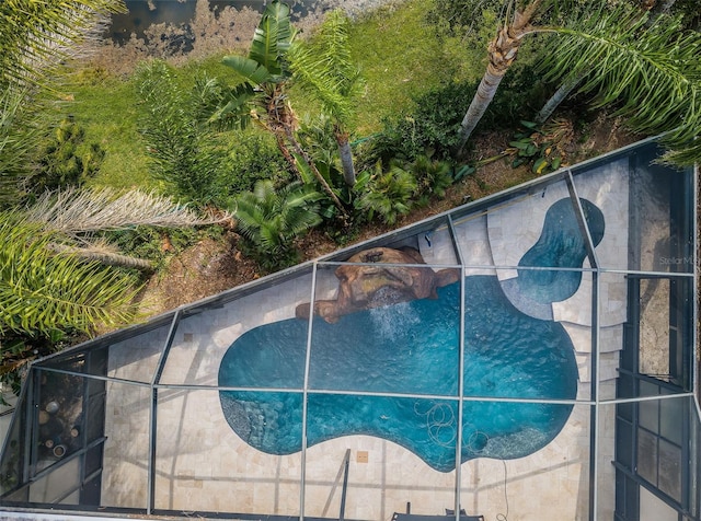 view of swimming pool featuring glass enclosure