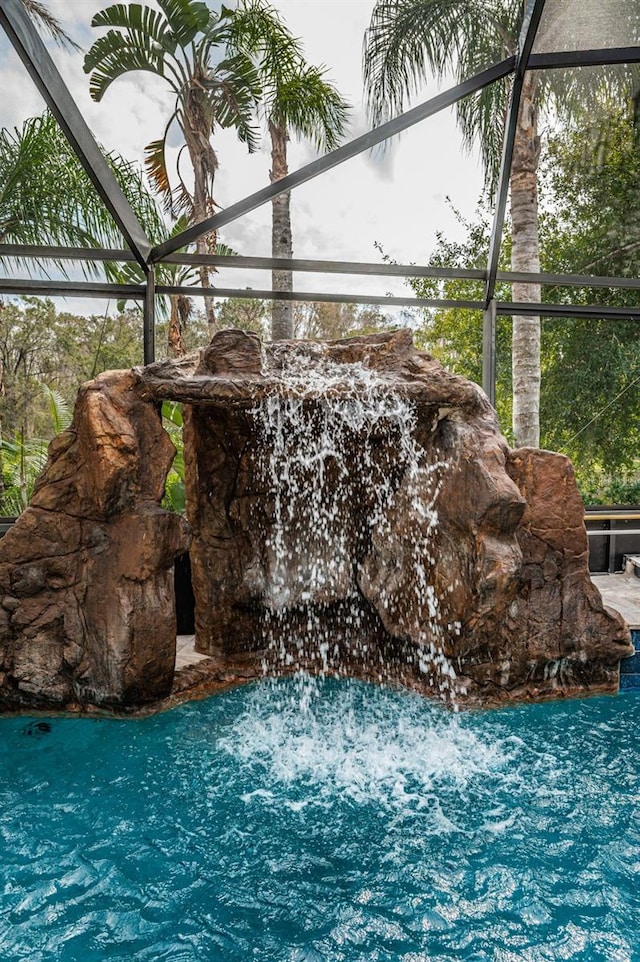 view of swimming pool with glass enclosure