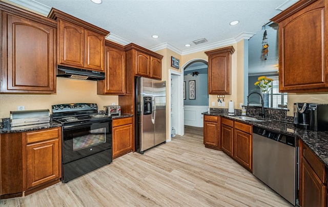 kitchen with sink, light hardwood / wood-style floors, stainless steel appliances, dark stone counters, and crown molding