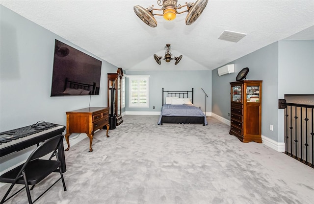 carpeted bedroom featuring a textured ceiling, lofted ceiling, and a wall unit AC