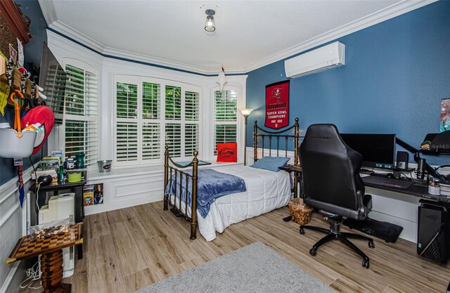 bedroom featuring crown molding, a wall mounted AC, and light wood-type flooring