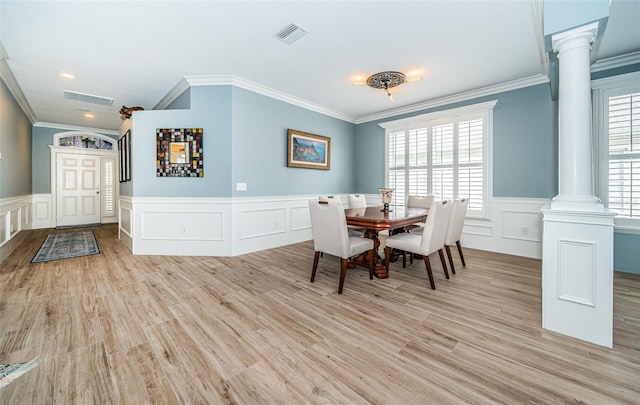 dining room with light hardwood / wood-style floors, crown molding, decorative columns, and plenty of natural light