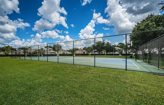 view of sport court with a yard and basketball hoop