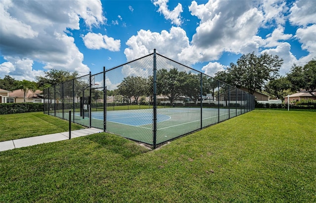 view of tennis court featuring a yard