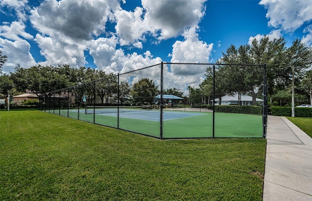 view of tennis court with a lawn