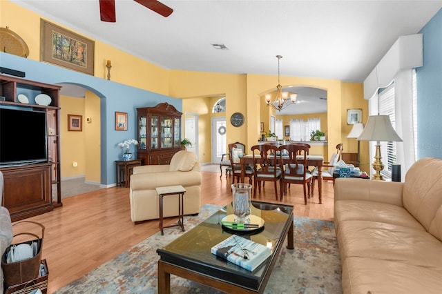 living room with light hardwood / wood-style floors and ceiling fan with notable chandelier