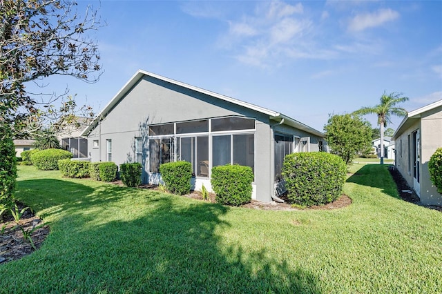 back of house featuring a yard and a sunroom