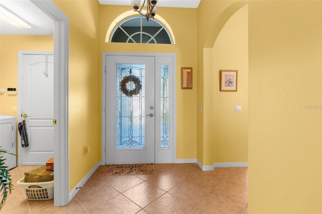 foyer entrance featuring light tile patterned floors and washer / dryer