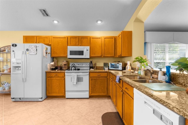 kitchen with sink, light tile patterned floors, and white appliances