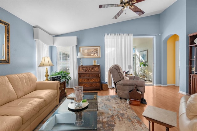 living room with ceiling fan, lofted ceiling, and light wood-type flooring