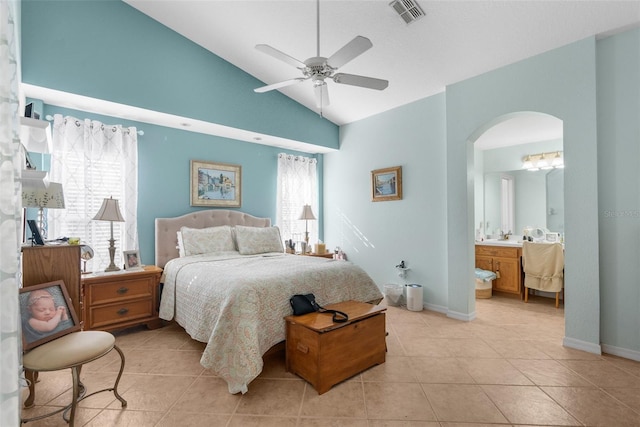 tiled bedroom with ceiling fan, lofted ceiling, and connected bathroom