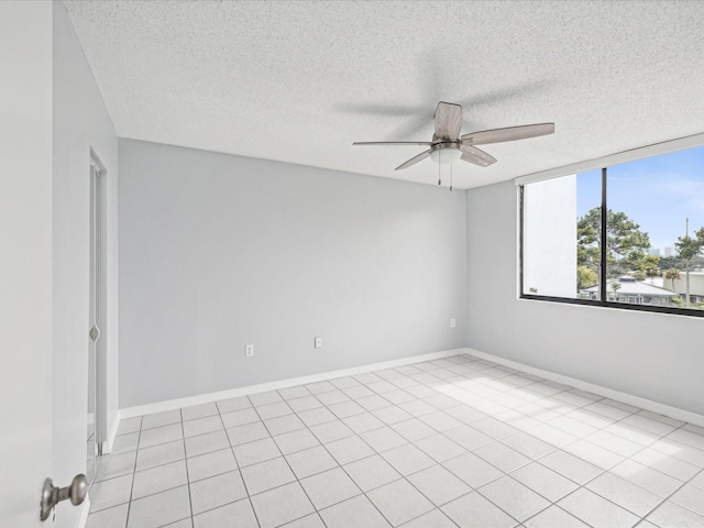 tiled empty room featuring ceiling fan and a textured ceiling