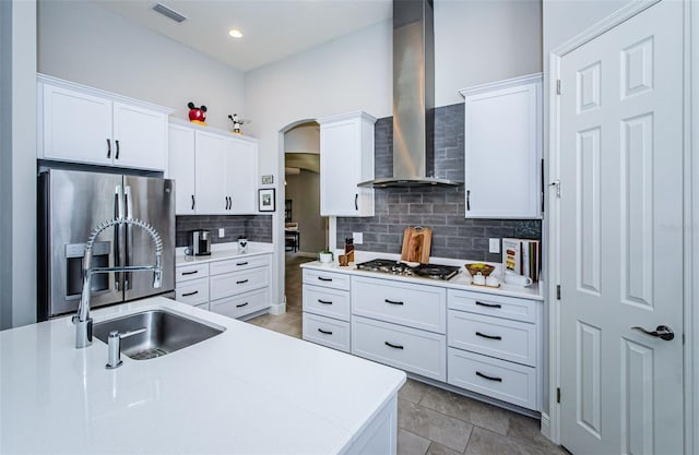 kitchen featuring white cabinets, sink, wall chimney exhaust hood, and appliances with stainless steel finishes