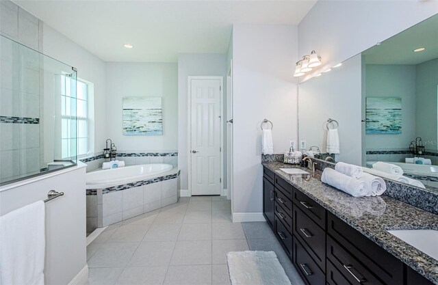 bathroom featuring vanity, tile patterned floors, and tiled tub