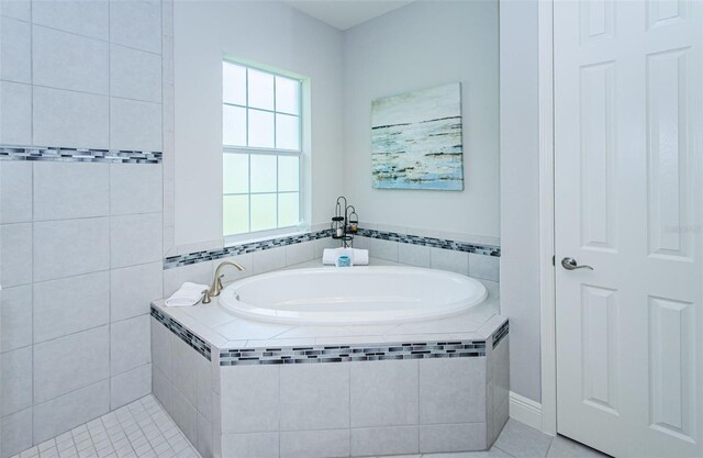 bathroom featuring tile patterned floors and tiled tub