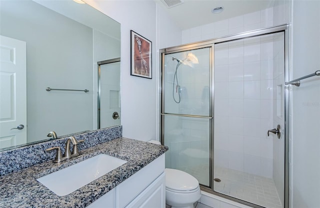 bathroom featuring vanity, toilet, and a shower with door