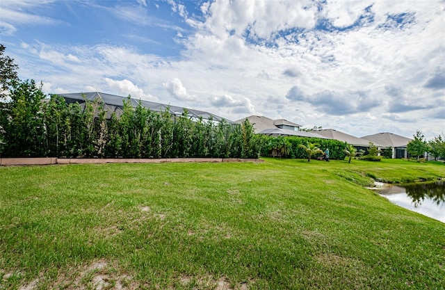 view of yard featuring glass enclosure and a water view