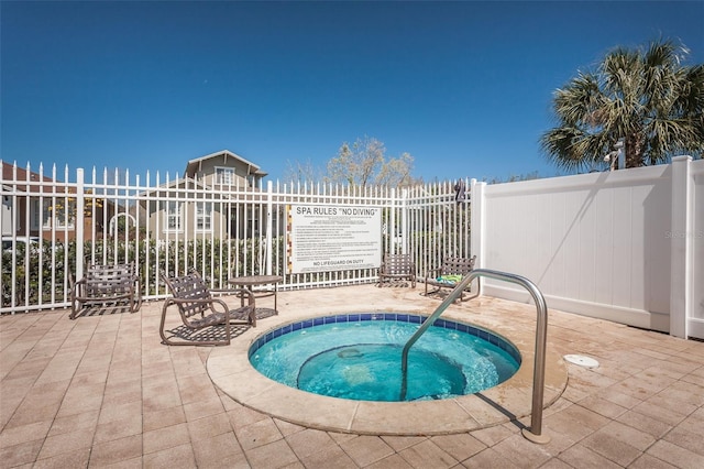 view of swimming pool featuring a hot tub