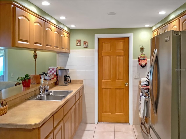 kitchen with appliances with stainless steel finishes, sink, and light tile patterned floors