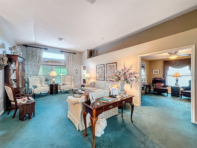 carpeted living room with ceiling fan, a textured ceiling, and lofted ceiling