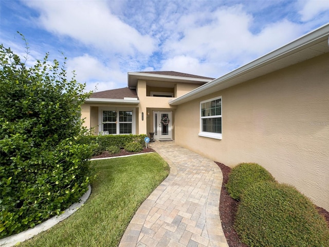 doorway to property with a yard