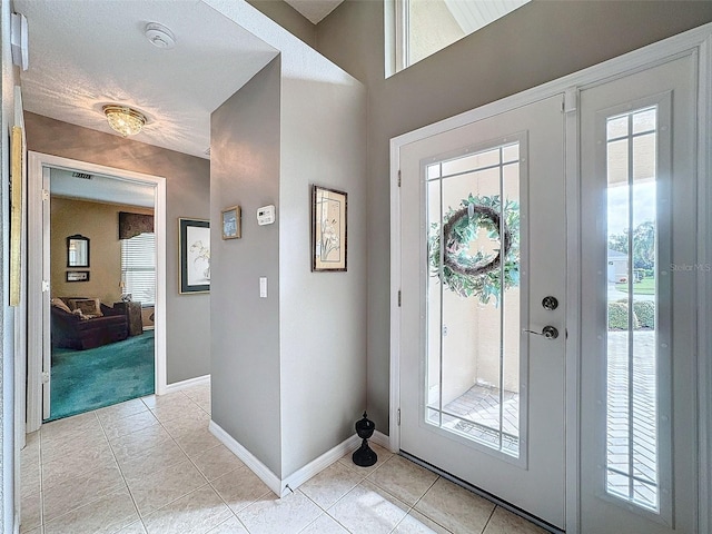 foyer featuring french doors and light tile patterned flooring