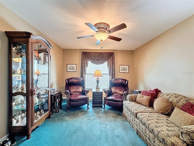 living area with a textured ceiling, carpet floors, and ceiling fan