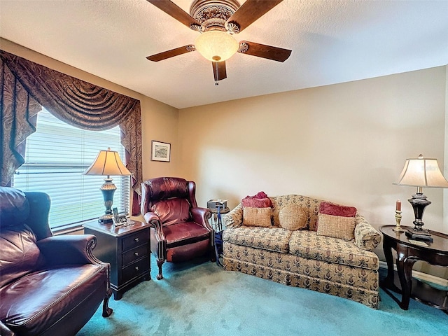 living room featuring ceiling fan, carpet flooring, and a textured ceiling