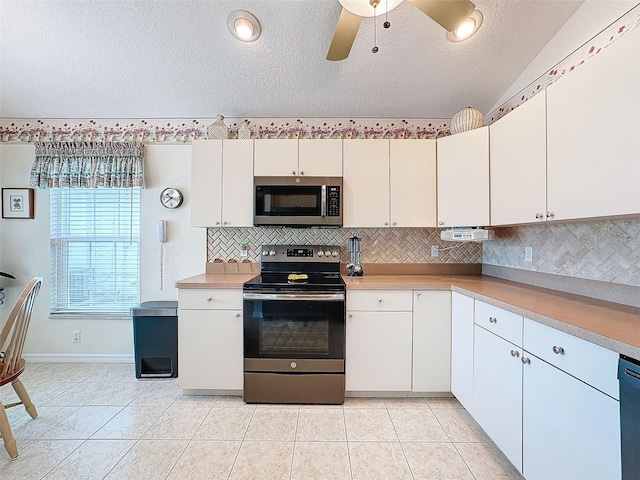 kitchen with light tile patterned flooring, white cabinetry, and stainless steel appliances