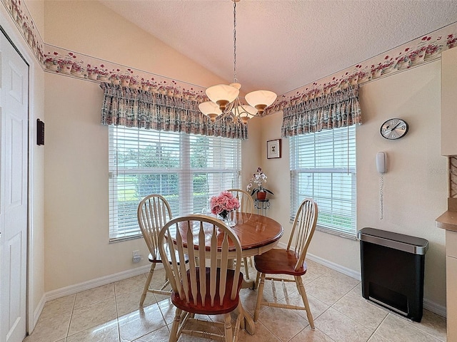 tiled dining area with an inviting chandelier, lofted ceiling, and a textured ceiling